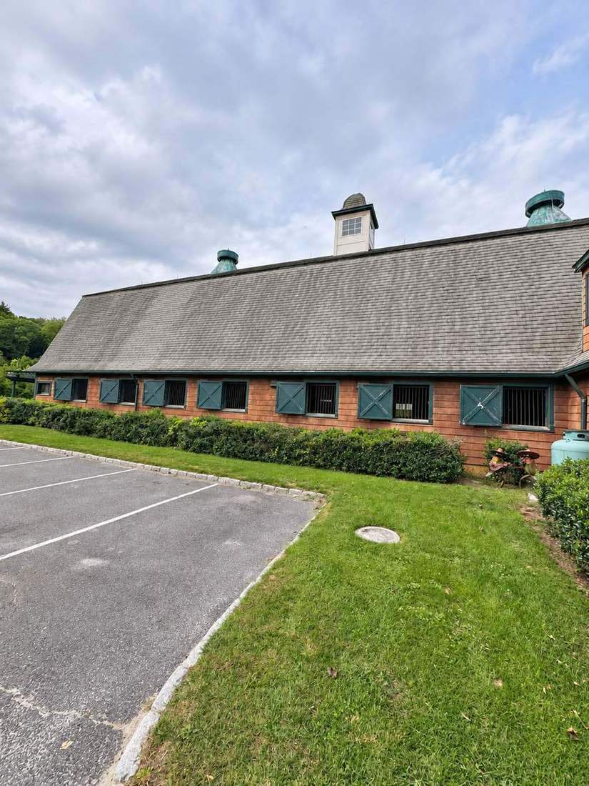 The stable barn, framed by summer lawns
