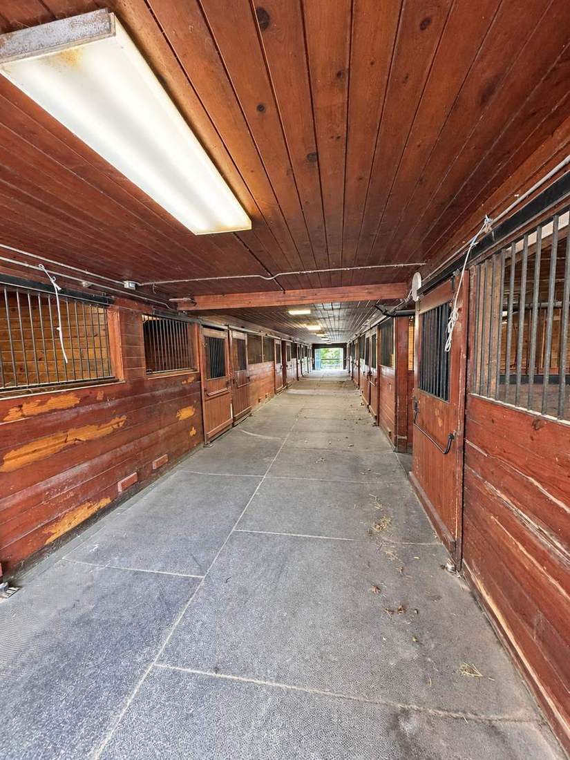 A long, light-filled stable aisle